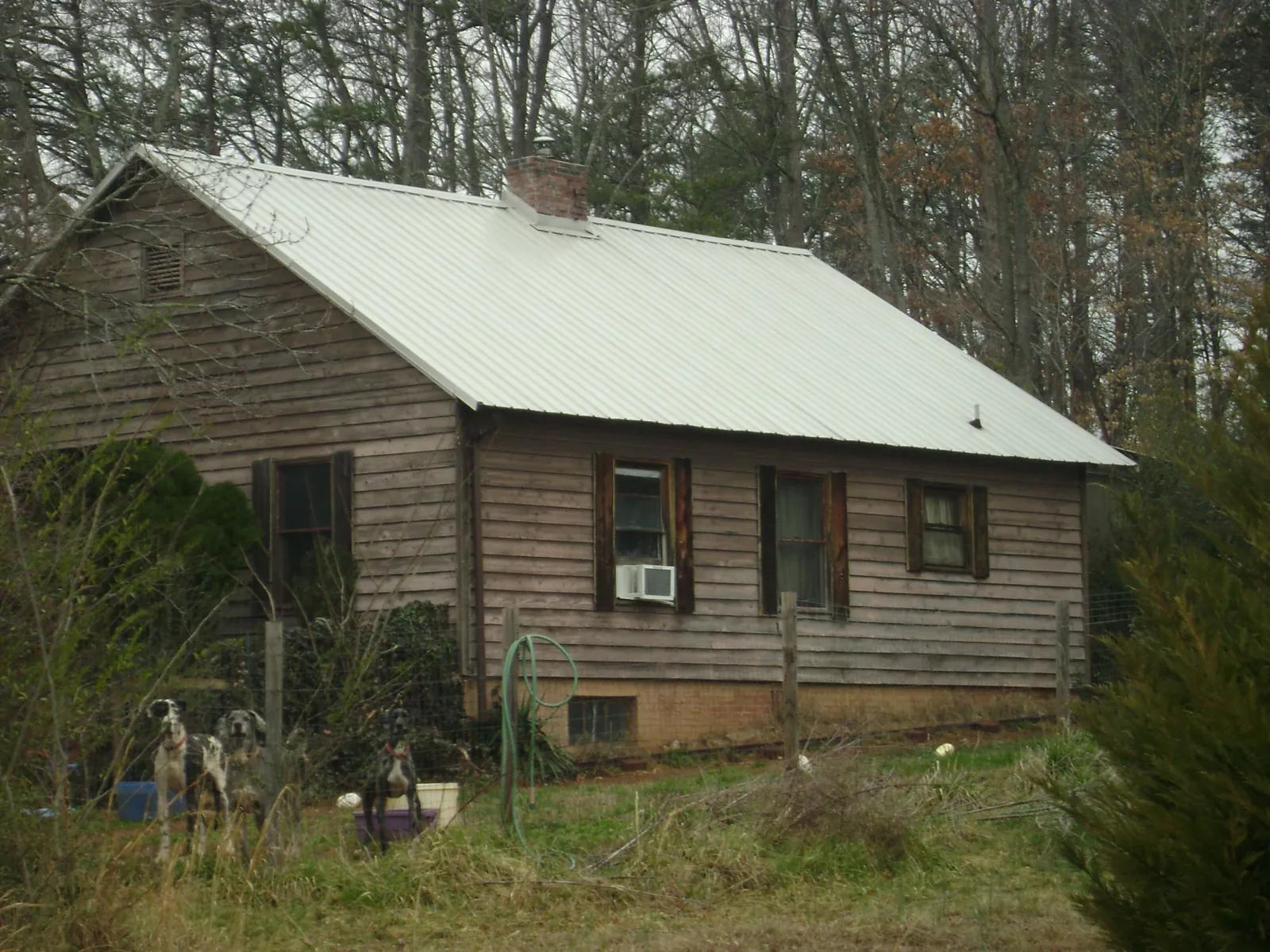 White metal roof on an old wood sided farmhouse, from a Metal Roof Installation job in Randall